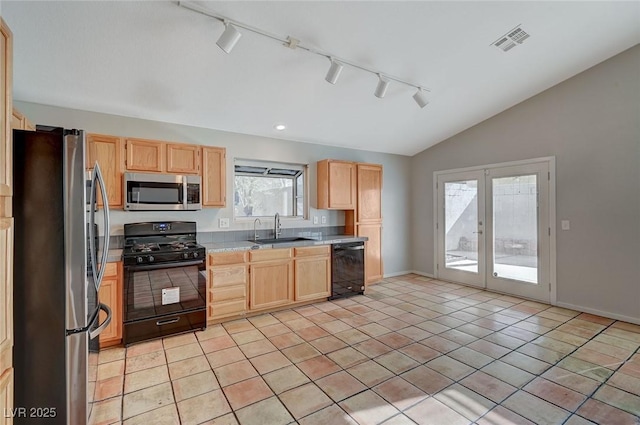 kitchen with light tile patterned floors, lofted ceiling, sink, and black appliances