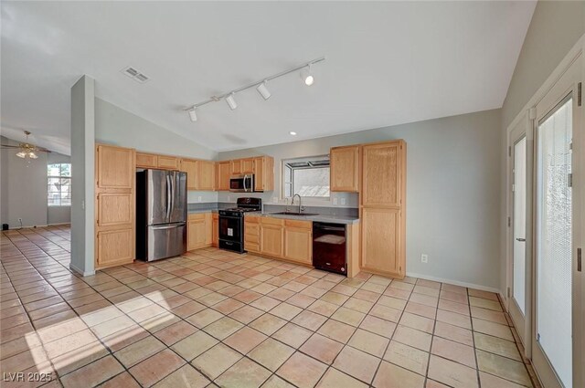 kitchen with lofted ceiling, light tile patterned floors, light brown cabinets, and black appliances