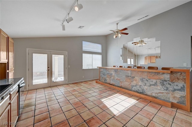 kitchen with light tile patterned floors, dishwasher, ceiling fan, vaulted ceiling, and french doors