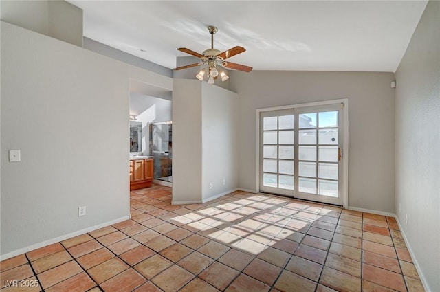 spare room featuring vaulted ceiling, light tile patterned floors, and ceiling fan