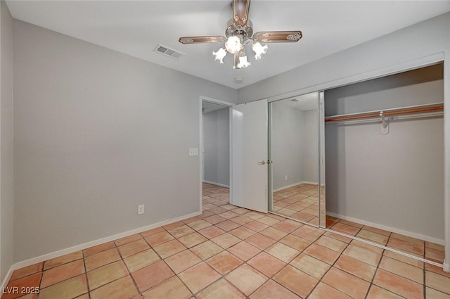 unfurnished bedroom with light tile patterned flooring, ceiling fan, and a closet