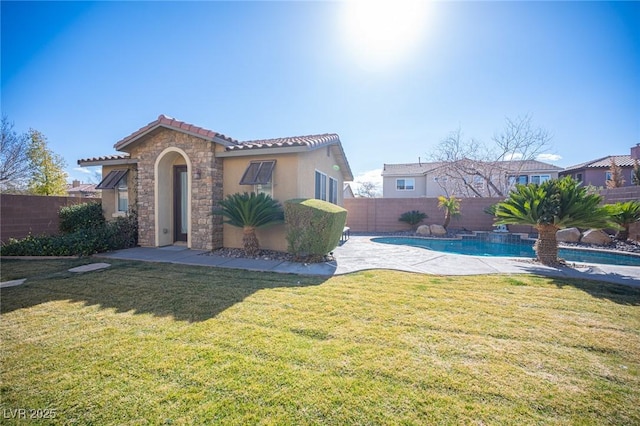 view of front of property with a fenced in pool and a front lawn