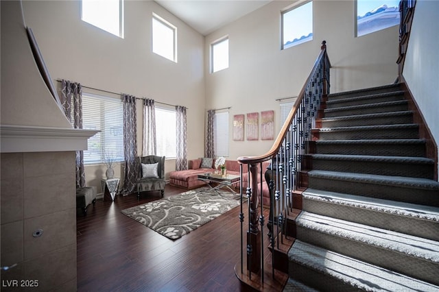 stairs featuring wood-type flooring and a high ceiling