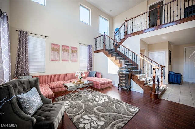 living room featuring a towering ceiling and wood-type flooring