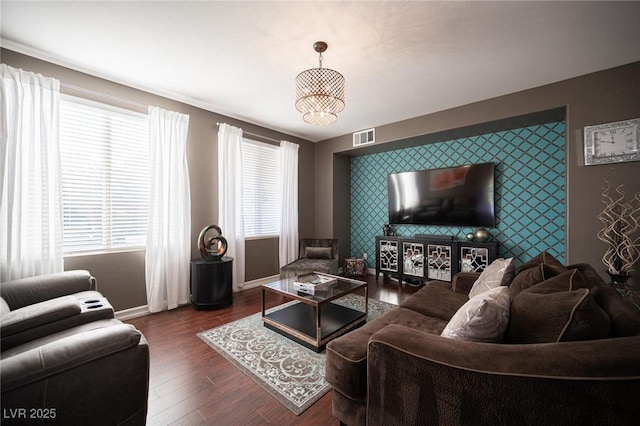 living room with dark hardwood / wood-style floors and an inviting chandelier