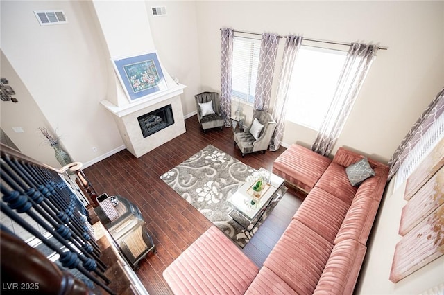 living room with dark hardwood / wood-style flooring and a high end fireplace