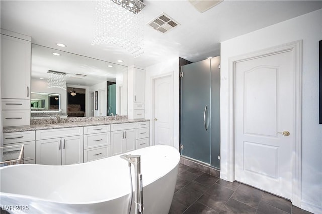 bathroom with vanity, tile patterned flooring, and plus walk in shower