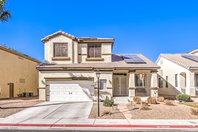 mediterranean / spanish-style home with a garage, central AC, and solar panels