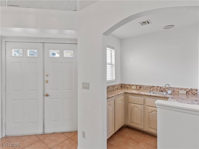 foyer with light tile patterned flooring and sink