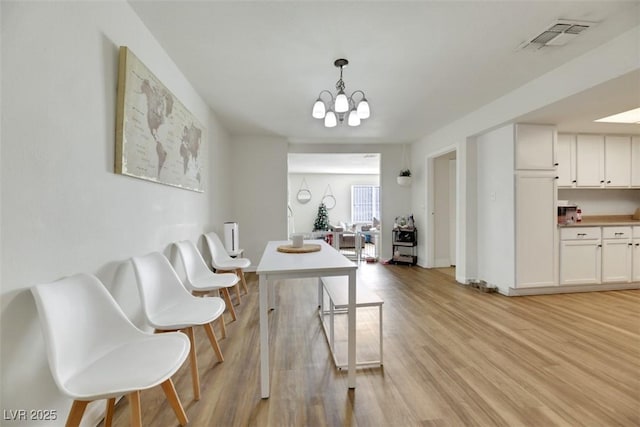 3473 Monte Carlo Dr, Las Vegas, NV 89121 - dining area featuring light wood finished floors and a chandelier