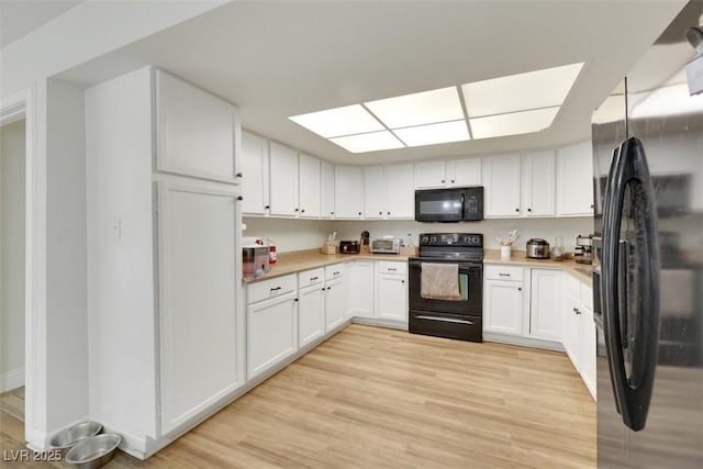3473 Monte Carlo Dr, Las Vegas, NV 89121 - kitchen with black appliances, light wood-style flooring, light countertops, and white cabinets