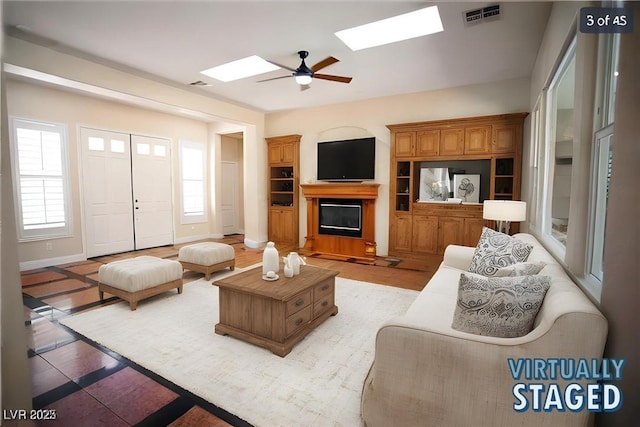 living room with a skylight and ceiling fan