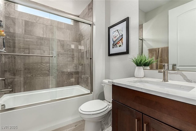 full bathroom with vanity, combined bath / shower with glass door, and toilet