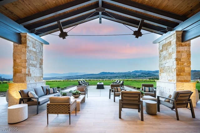 patio terrace at dusk with an outdoor hangout area and a mountain view