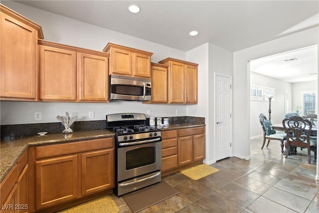 kitchen featuring dark stone counters and appliances with stainless steel finishes