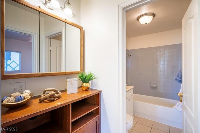 full bathroom featuring tile patterned floors, toilet, tiled shower / bath combo, and vanity