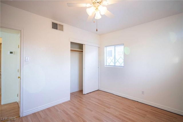 unfurnished bedroom with ceiling fan, light wood-type flooring, and a closet