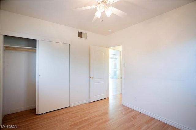 unfurnished bedroom featuring ceiling fan, light wood-type flooring, and a closet