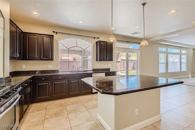 kitchen featuring pendant lighting, appliances with stainless steel finishes, sink, and light tile patterned floors