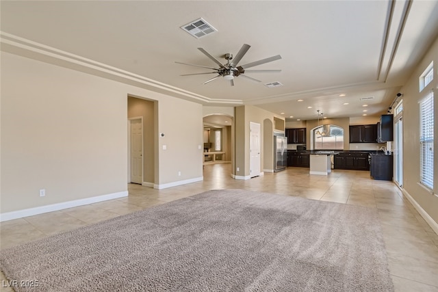 unfurnished living room featuring ceiling fan and light tile patterned floors