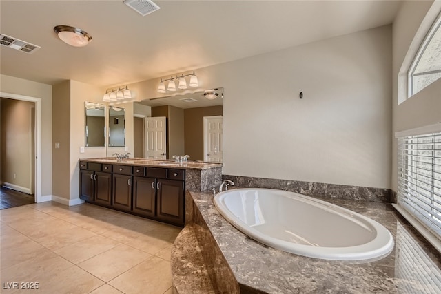 bathroom featuring vanity, tile patterned flooring, and tiled bath