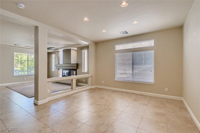 unfurnished living room featuring ceiling fan and light tile patterned floors