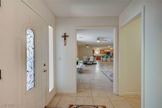 tiled foyer entrance with ceiling fan and a healthy amount of sunlight