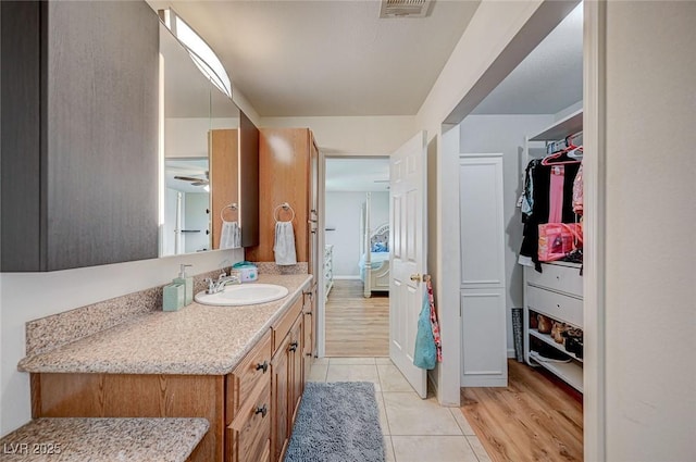 bathroom with tile patterned flooring, vanity, and ceiling fan