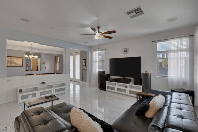 living room with ceiling fan with notable chandelier, french doors, and a healthy amount of sunlight