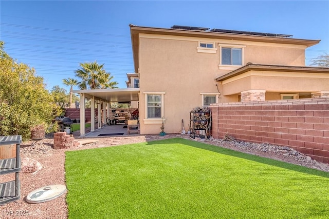 rear view of property with a lawn and a patio