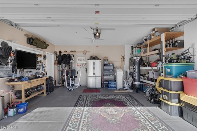 garage with a garage door opener, fridge, and a workshop area