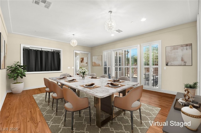 dining room featuring hardwood / wood-style flooring and a chandelier