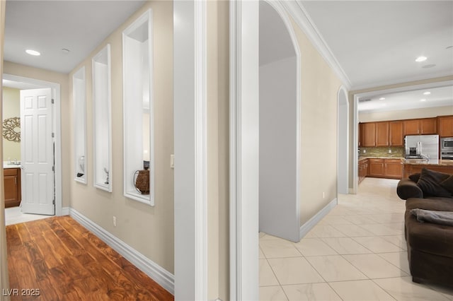 hall featuring crown molding and light tile patterned flooring