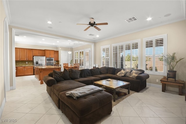 tiled living room featuring ceiling fan and ornamental molding