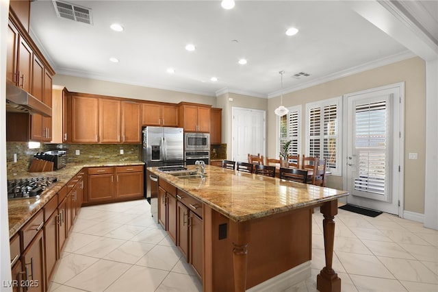 kitchen with a breakfast bar area, crown molding, decorative light fixtures, stainless steel appliances, and a kitchen island with sink