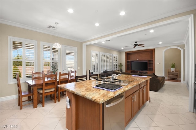 kitchen with crown molding, decorative light fixtures, a center island, stainless steel dishwasher, and light stone countertops