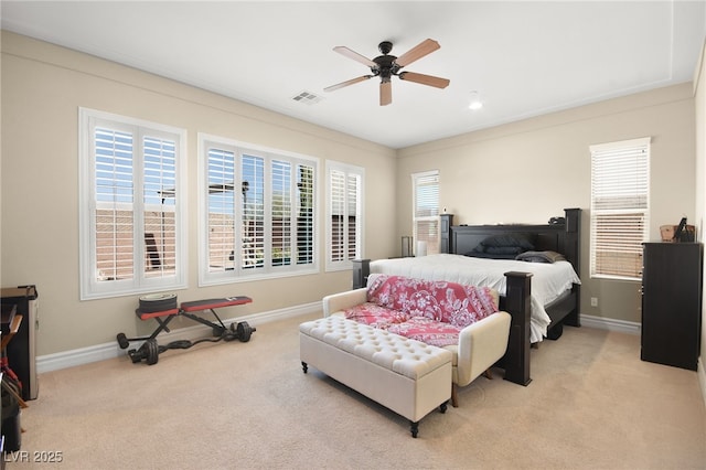 bedroom with light carpet, multiple windows, and ceiling fan