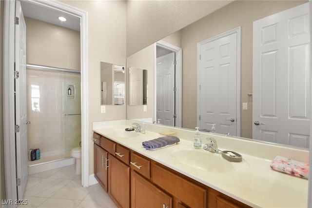 bathroom featuring a shower with door, vanity, and toilet