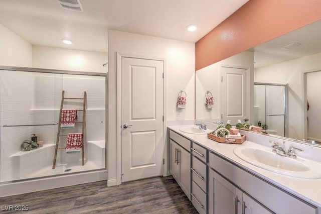 bathroom featuring hardwood / wood-style flooring, vanity, and an enclosed shower