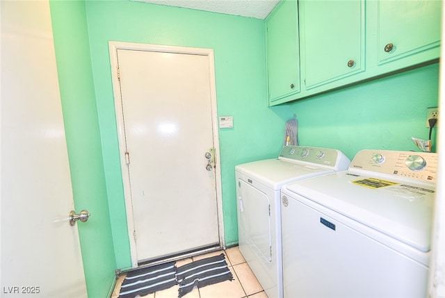 laundry area featuring light tile patterned flooring, cabinets, and separate washer and dryer