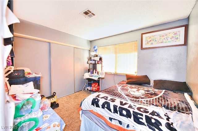 bedroom with a closet, carpet flooring, and a textured ceiling