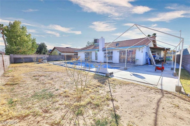 back of house featuring a fenced in pool and a patio area