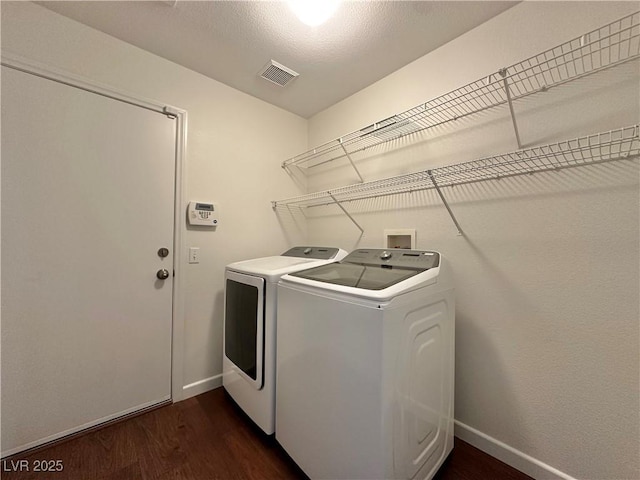 washroom with dark hardwood / wood-style flooring and washer and dryer