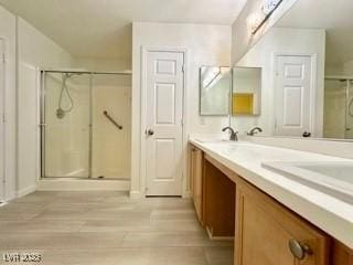 bathroom featuring vanity, wood-type flooring, and a shower with door