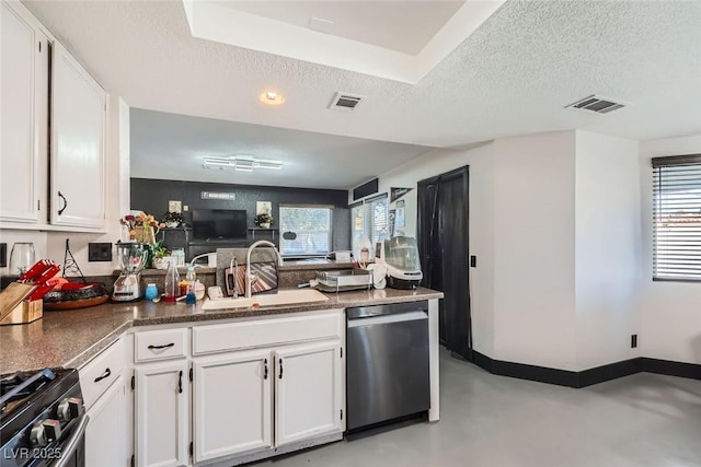 kitchen featuring dishwasher, sink, white cabinets, gas range, and a textured ceiling