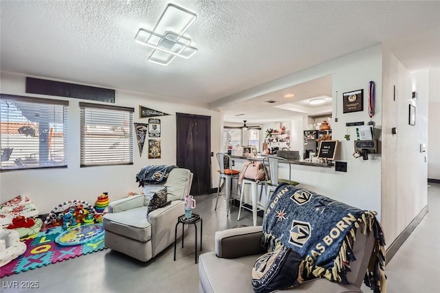 living room with plenty of natural light, concrete floors, and a textured ceiling