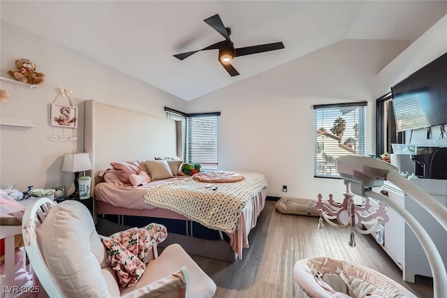 bedroom featuring ceiling fan, dark hardwood / wood-style floors, vaulted ceiling, and multiple windows