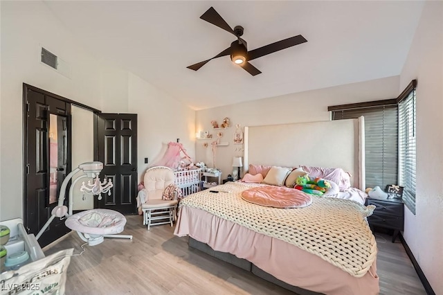 bedroom with ceiling fan, vaulted ceiling, and hardwood / wood-style floors