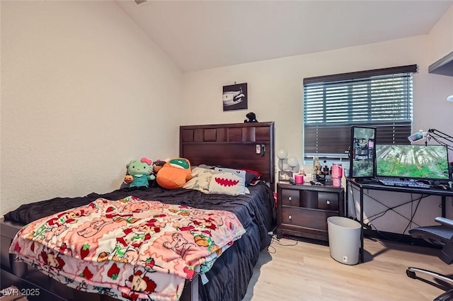 bedroom with light hardwood / wood-style flooring and vaulted ceiling