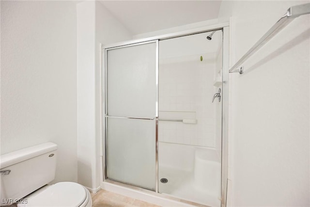 bathroom with a shower with shower door and toilet